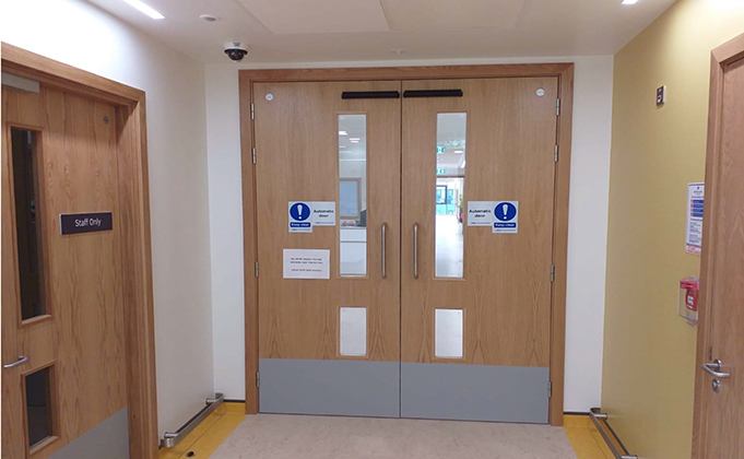 Double timber fire door with automation and large vision panels