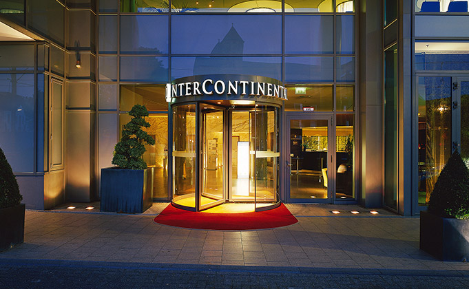Entrance to a high end hotel featuring am automatic revolving door to control the passage of movement