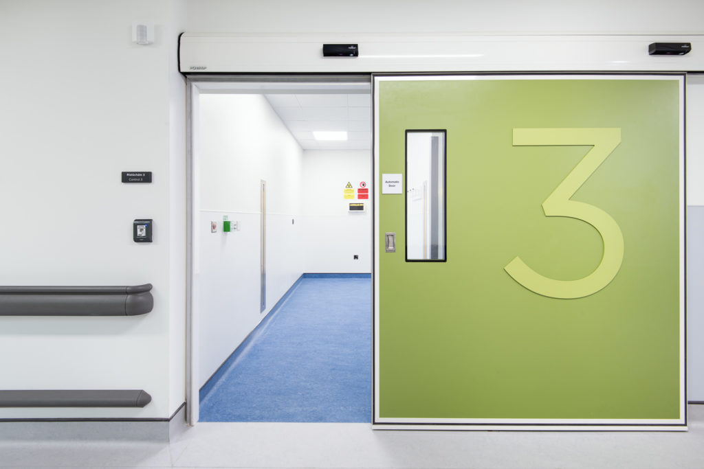 Cleanroom doors with vision panel, finished in green colour and with a surface mounted number 3 sign