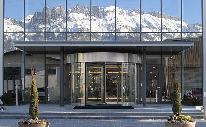 Large glazed building featuring a large automatic revolving door set