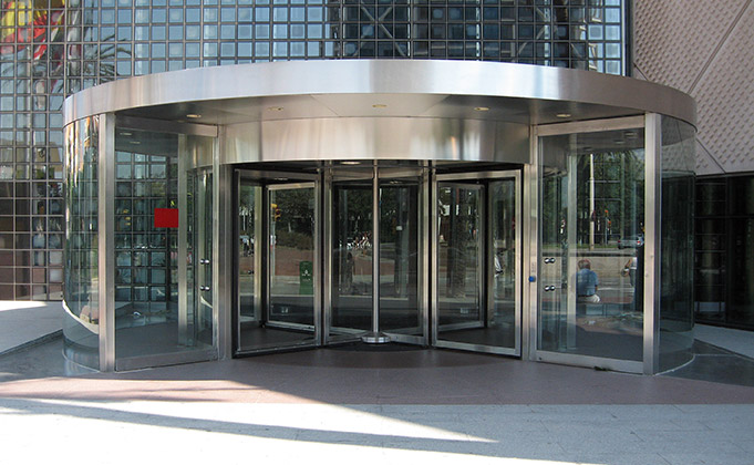 Modern commercial building with large commercial revolving doors featuring automatic access control