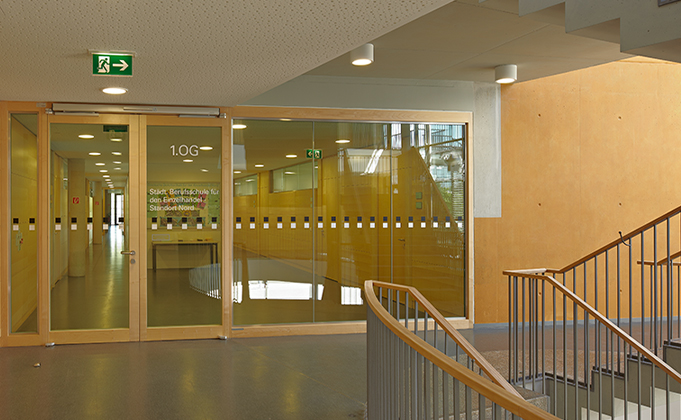 Automatic glazed swing door with integrated surrounding glazed screen installed off stairwell area