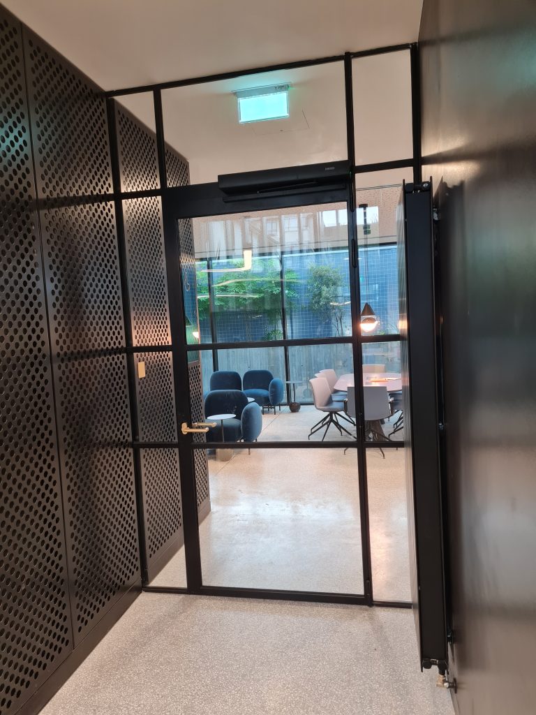 thin profile, steel framed glass office door with surrounding glass panels