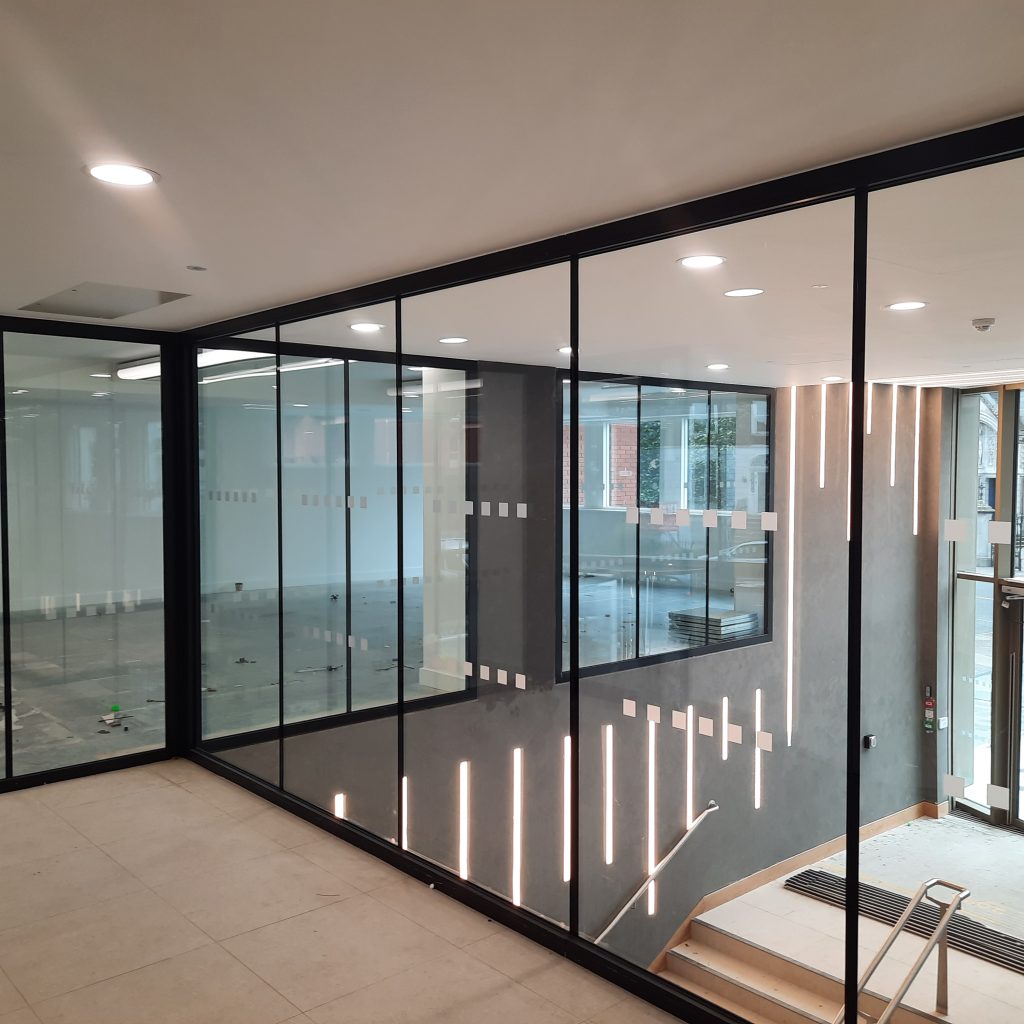 glazed fire screen overlooking reception lobby area of modern commercial building