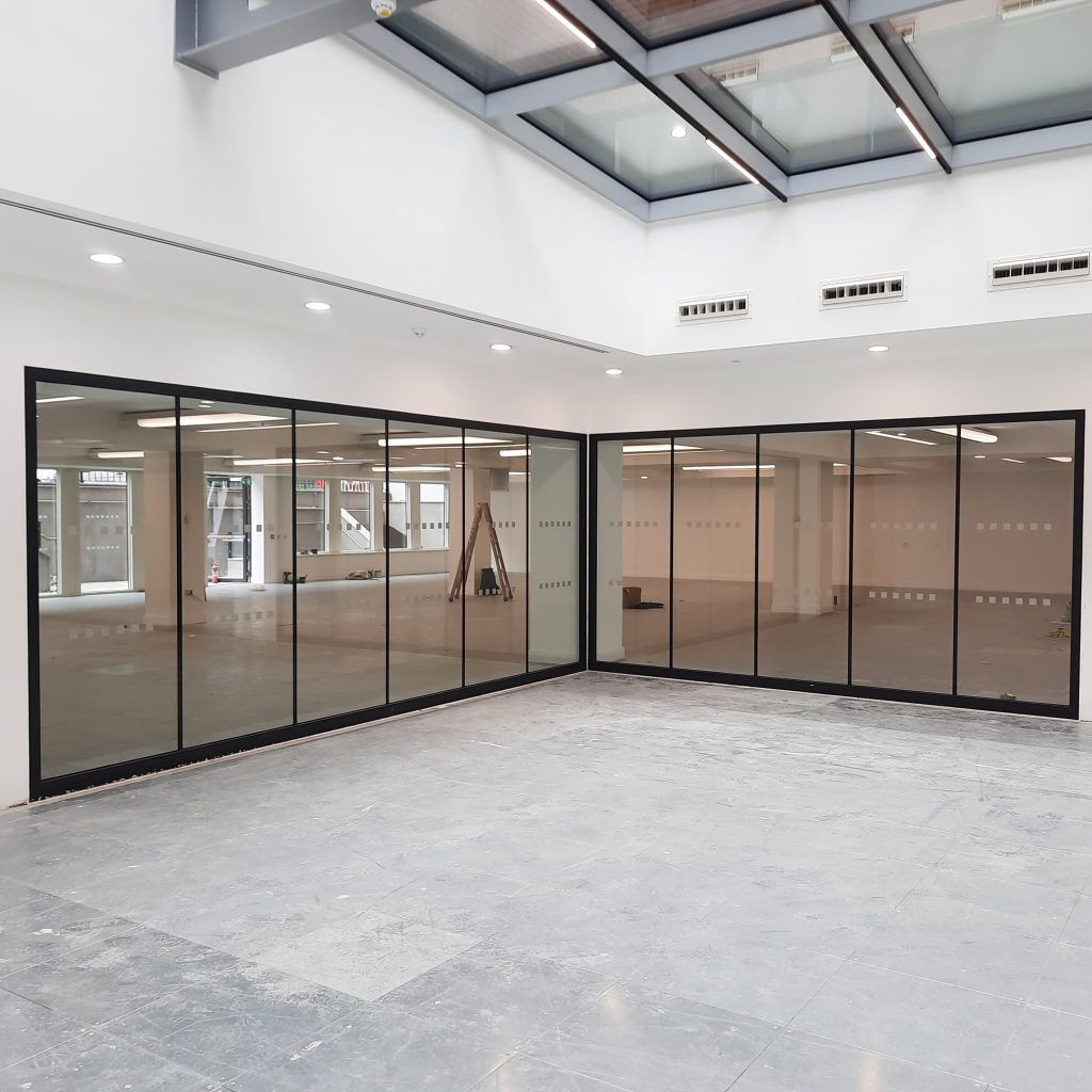 view of corner glazed wall in open plan communal space in modern office development
