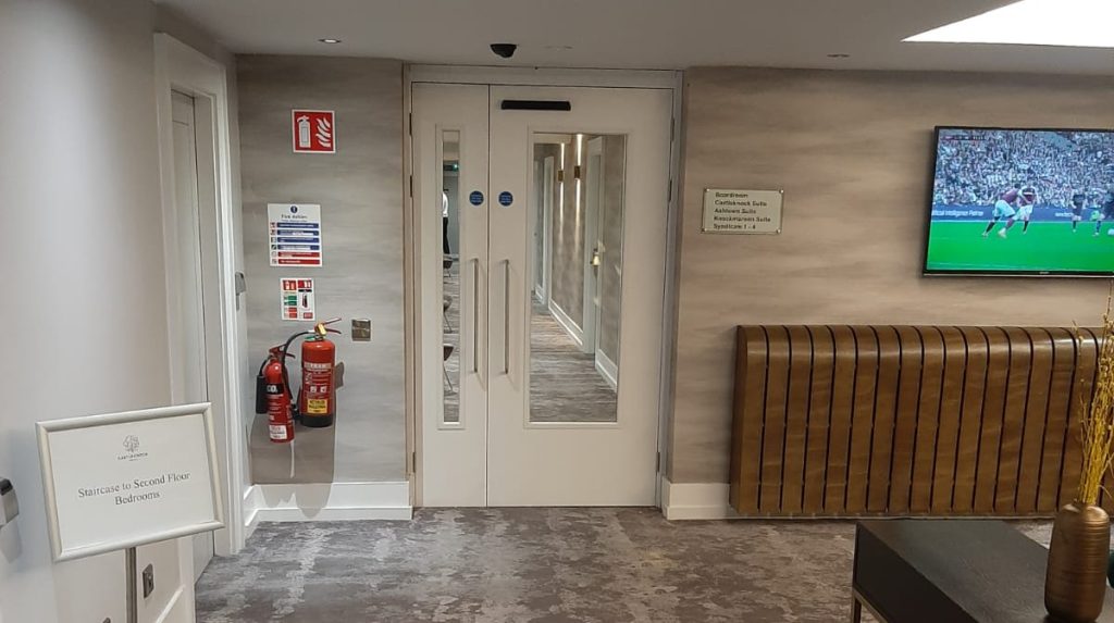 timber fire doorset with visison panels and fob access on hotel corridor
