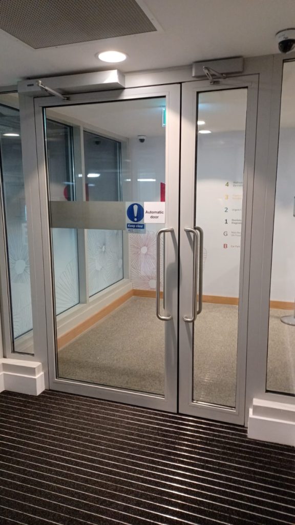 Steel glazed door with glazed side panel and integrated automation