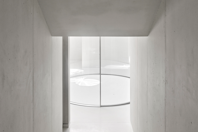 Wide angle view of curved glass doors in modern concrete finish room