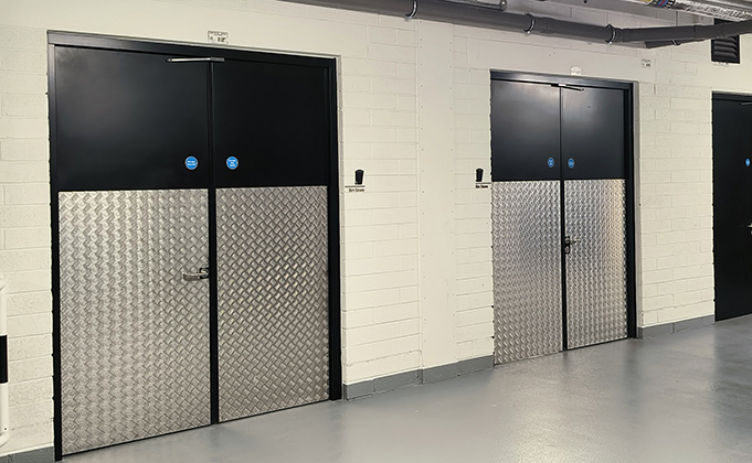 Basement steel doors with protective cladding for bin storage
